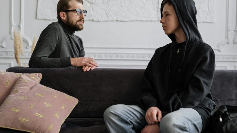 two people talking sofa serious hoodie young consultation