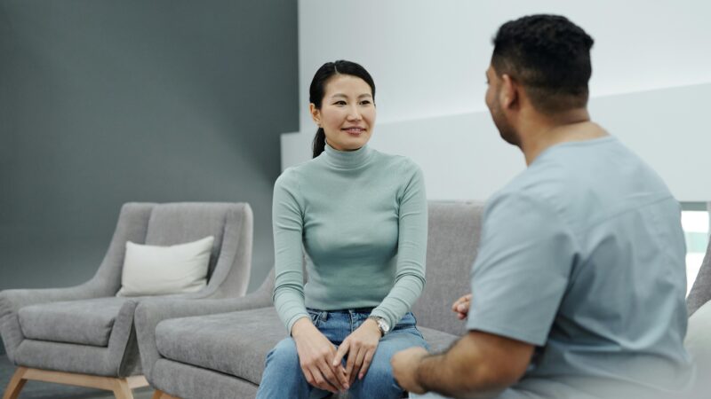 two people talking healthcare professional scrubs sofa