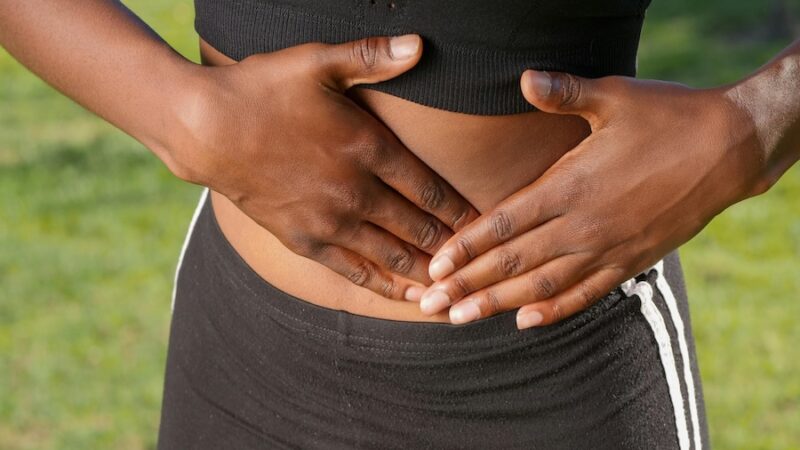 holding stomach tummy pain standing