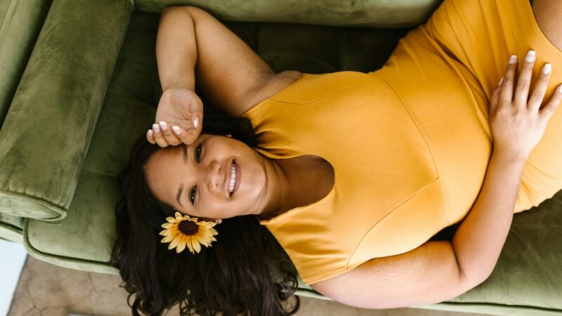 person lying down with sunflower in hair yellow